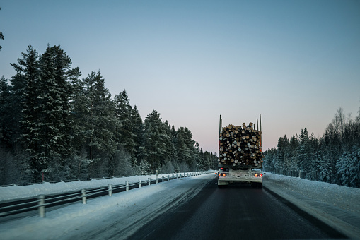 Vinterväg i Sverige. Bilden är tagen från bil bakom en timmerbil.