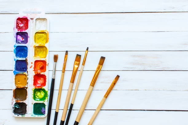 istock Paints and brushes on a white wooden background 642705982