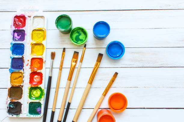 istock Paints and brushes on a white wooden background 642705998
