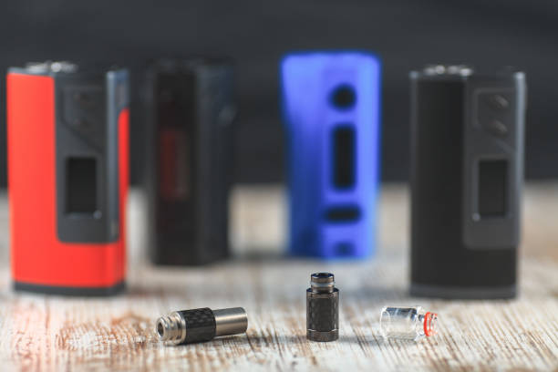 Drip Tips and electronic cigarette mods on the background stand on the table.