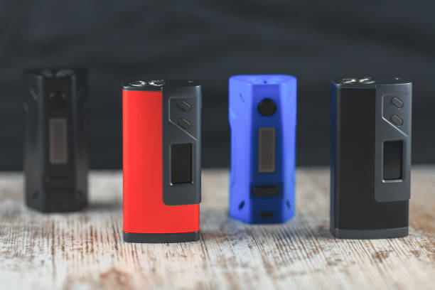 istock Black, blue and red electronic cigarette mods stand on the table. 642708342