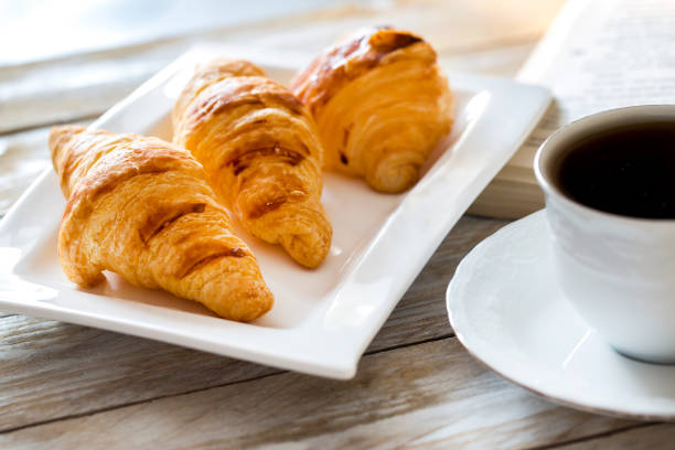 istock Croissants with coffee on the wooden table 642723972