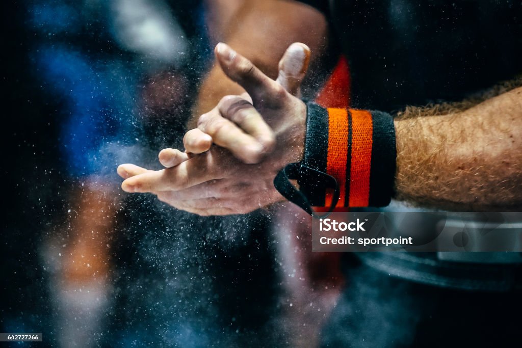 male powerlifter hand in talc and sports wristbands preparing to bench press Powerlifting Stock Photo