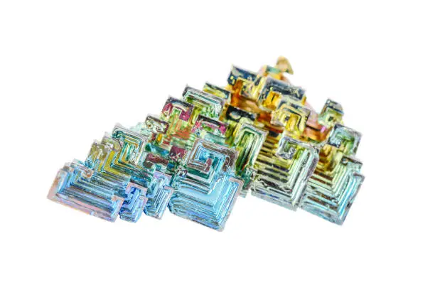 Artificially grown skeletal crystals of bismuth with tarnish isolated on a white background