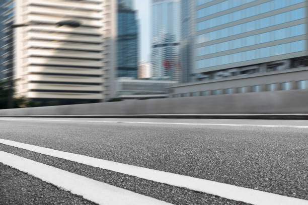 istock empty asphalt road by modern office block,Hong Kong 642764982