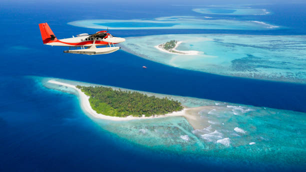 Sea plane flying above Maldives islands stock photo