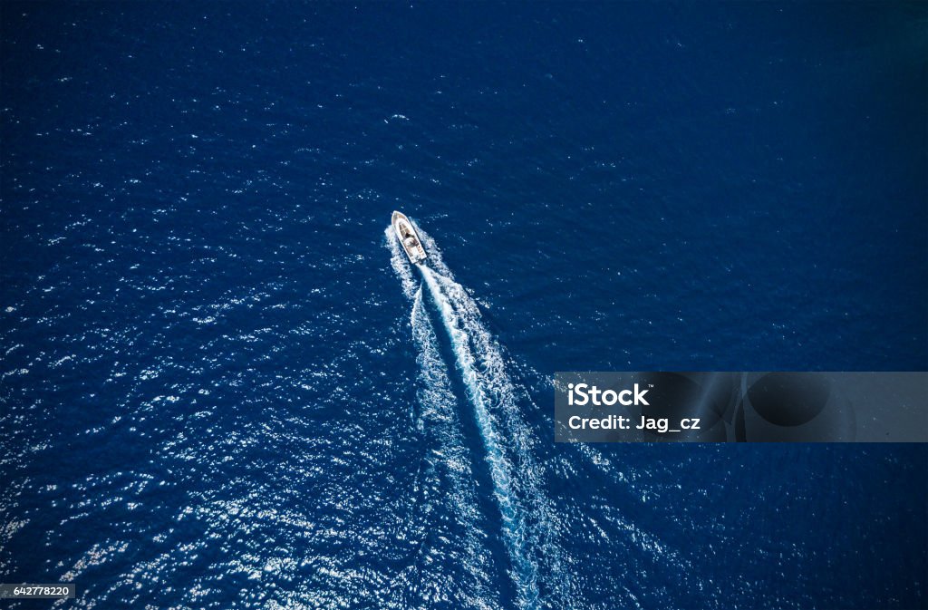 Aerial view of small boat flowing in sea Aerial view of small boat flowing in sea, travel and vacation concept Speedboat Stock Photo