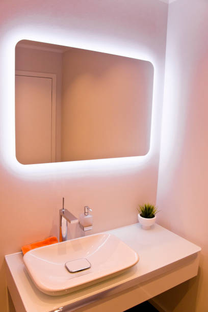 istock Modern bathroom sink and indirectly lit mirror 642780530