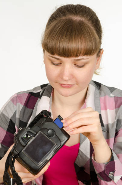 photographer inserts a flash drive into the camera - driving school flash imagens e fotografias de stock