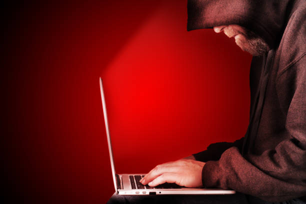computadora con capucha hacker rojo fondo - acicalar fotografías e imágenes de stock