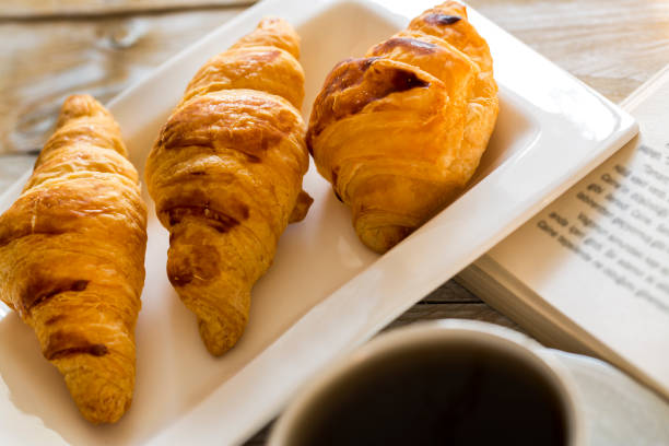 istock Book and croissants with coffee on the wooden table 642791880