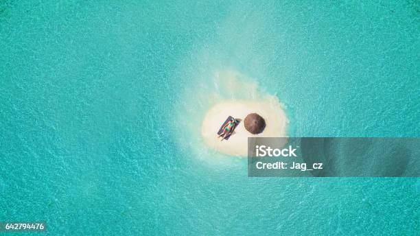 Joven Mujer Tomando El Sol En La Pequeña Isla De Arena Foto de stock y más banco de imágenes de Isla