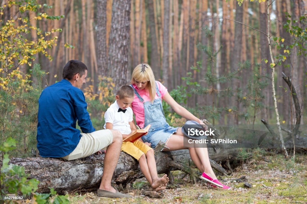 Young family relaxing on the nature. Young family relaxing on the nature. Parents spend time with his son in the fun atmosphere. Grove Stock Photo