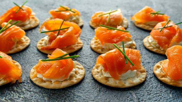 istock Smoked Salmon and soft chees canapes appetizers with chives on stone table 642799456