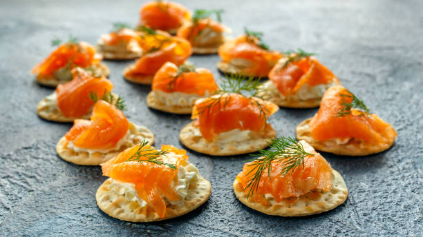 istock Smoked Salmon and soft chees canapes appetizers with chives on stone table 642799562