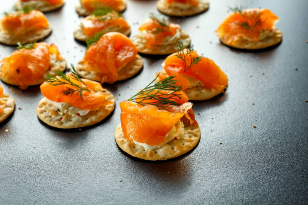 istock Smoked Salmon and soft chees canapes appetizers with chives on stone table 642800026