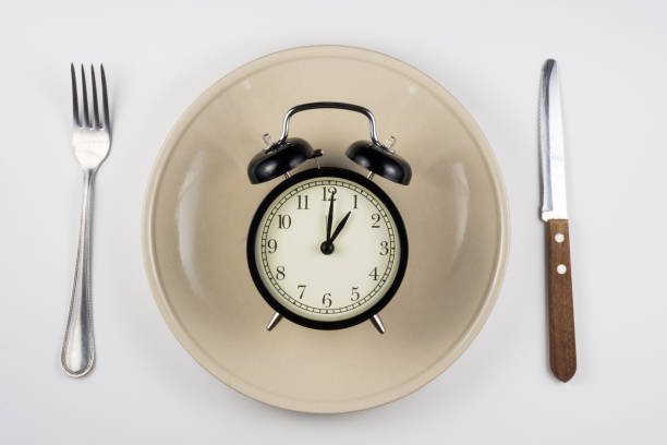 istock On the plate is an alarm clock, lying next to a knife and fork, white background, top view 642803344