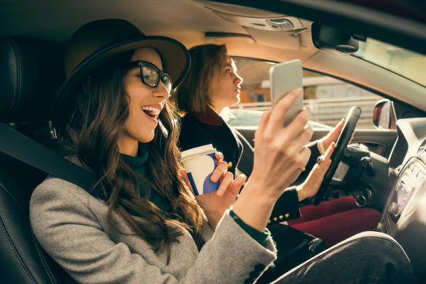 две лучшие подруги наслаждаясь поездкой в машине - driving mobile phone car talking стоковые фото и изображения