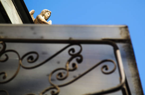 Concrete sculpture of praying angel on the front of street house