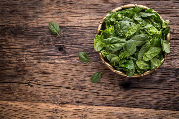 istock Spinach leaves.Fresh spinach leaves in retro bowl on oak wood board. Selective focus 642813452