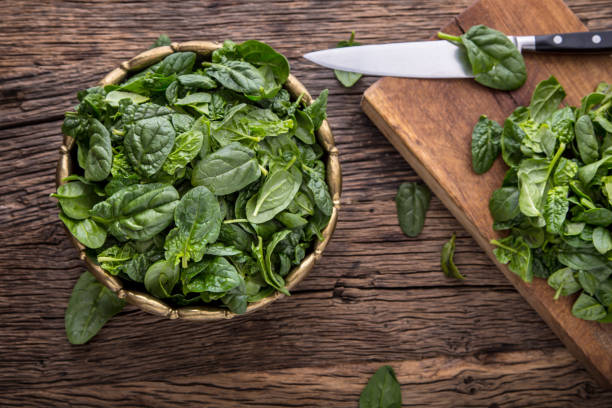 istock Spinach leaves.Fresh spinach leaves in retro bowl on oak wood board. Selective focus 642813464