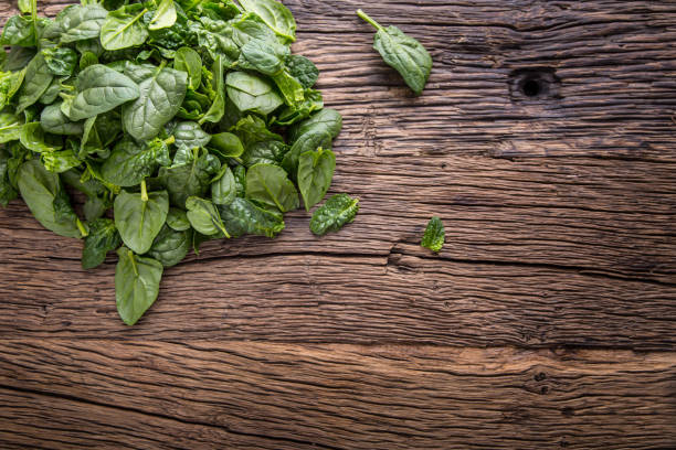istock Spinach leaves.Fresh spinach leaves in retro bowl on oak wood board. Selective focus 642813500