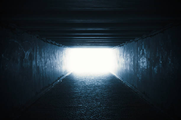 Empty dark tunnel with light in the end stock photo