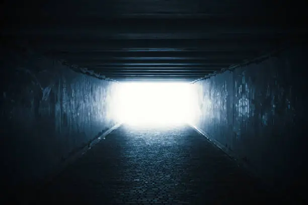 Photo of Empty dark tunnel with light in the end
