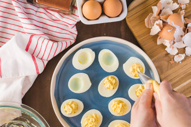 preparación de huevos diabólicos - deviled fotografías e imágenes de stock