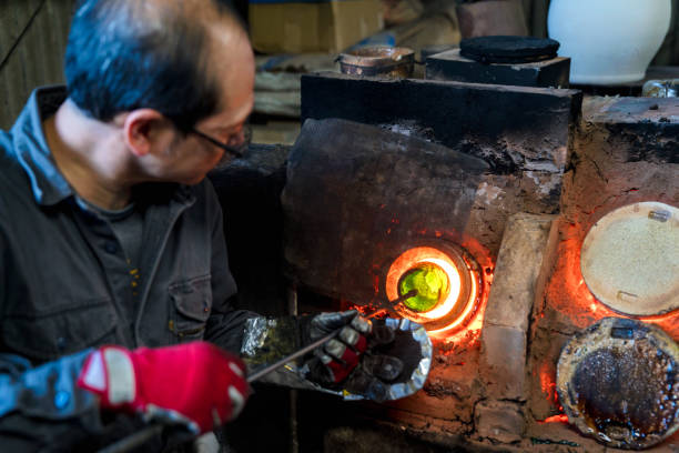 istock Glassblower heating his glass in a kiln 642828088
