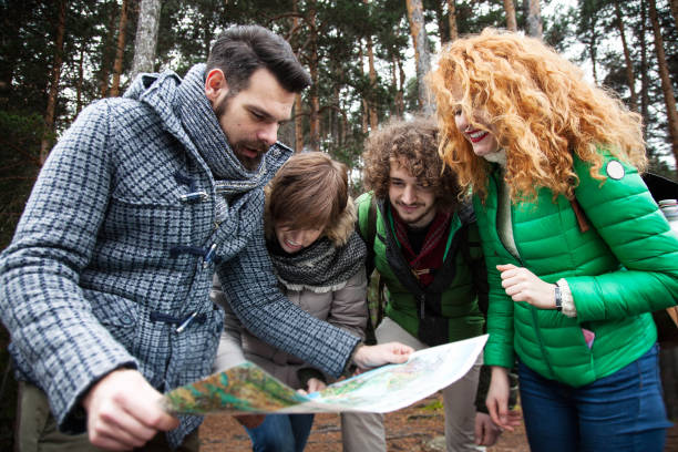 istock Group of friend into wood watching map 642830982