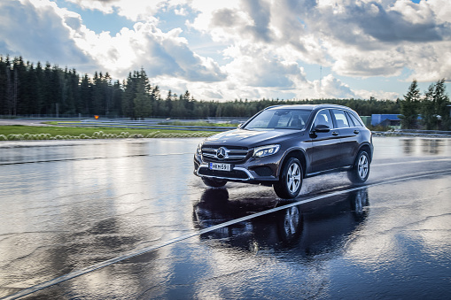 Nokia, Finland - August 24, 2016: Summer tire test is held at the proving ground. Test-driver performs a wet handling test on Mercedes-Benz GLC to determine the tire which provides the best grip.