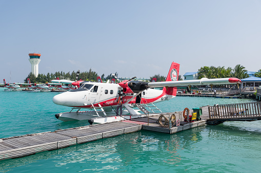 Male, Maldives, December 25 2016: Water Taxi - Seaplane at wooden jetty waiting for boarding to fly tourists to the many different atolls and islands of the Maldives. Trans Maldivian Airways Water Taxi, Male, Seaplane Airport, Maldives.