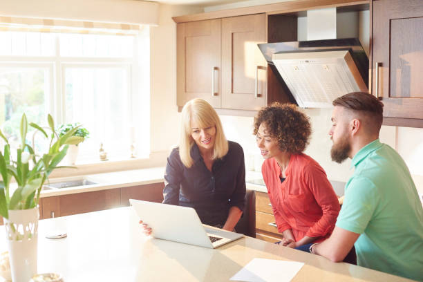 istock estate agent with couple looking at figures 642872978