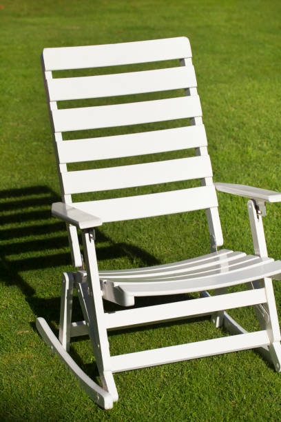 istock Empty wooden rocking chair on lawn, shadow behind 642873330