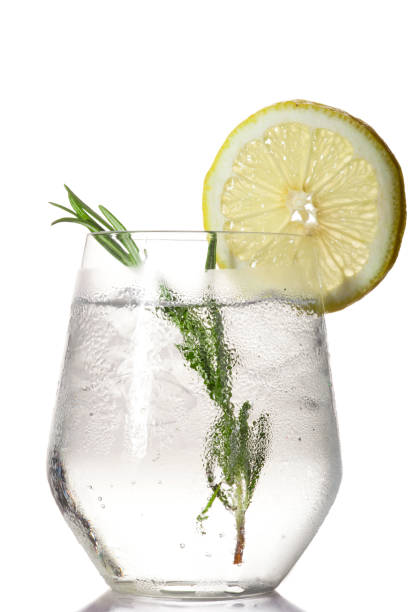 verre avec une boisson alcoolisée au citron vert et glace - tonic water photos et images de collection