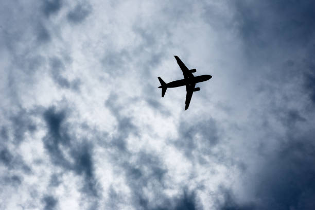 istock Silhouetted airplane on stormy sky 642949388
