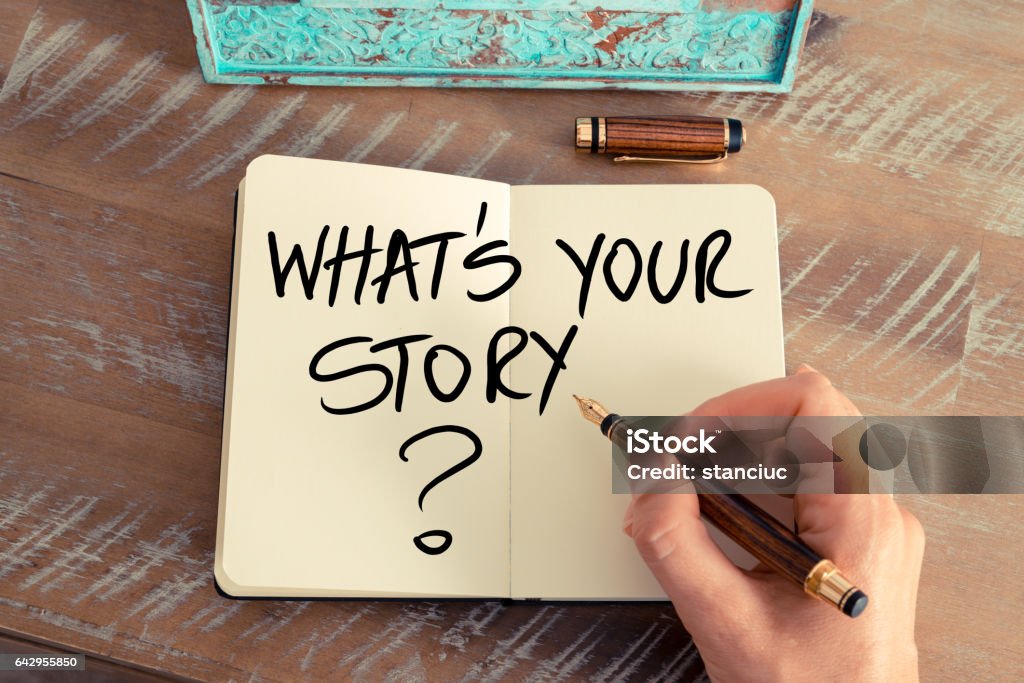 Question What Is Your Story ? Retro effect and toned image of a woman hand writing a note with a fountain pen on a notebook. Handwritten Question What Is Your Story ? as success and evolution concept image Handwriting Stock Photo