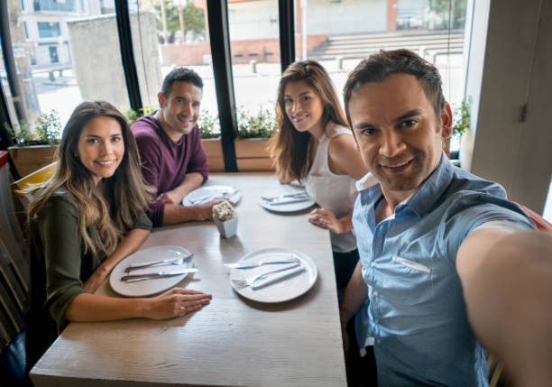 istock Man taking a selfie with friends at a restaurant 642958670