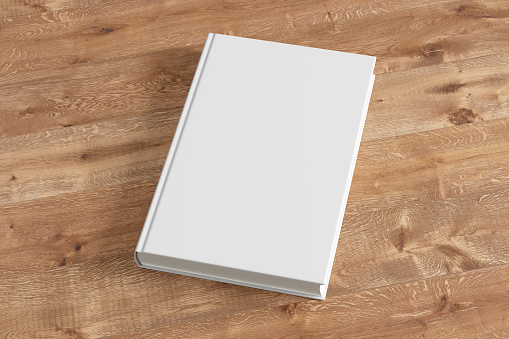 Blank white book cover on wooden background. Isolated with clipping path. 3d render