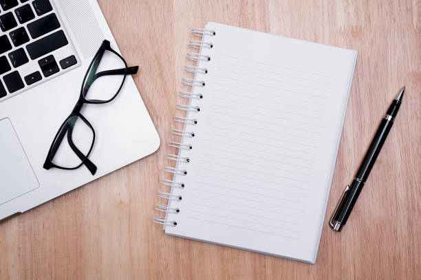 istock Notebook, glasses, pen, laptop, on a wooden background 642994358