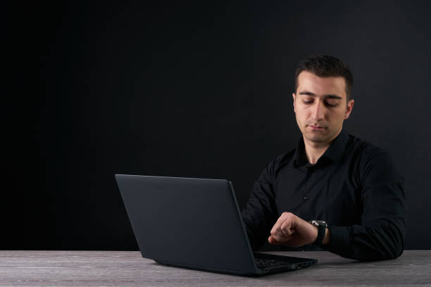 istock Businessman looking at clock and and working on a laptop. 643009520