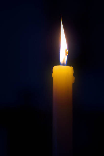 istock Dark room lit by single candle with quite flame 643015016