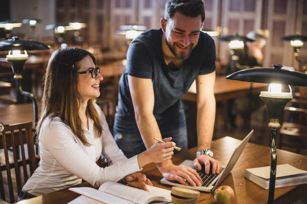 istock Two Students in The Library Studying Beside a Laptop 643017886