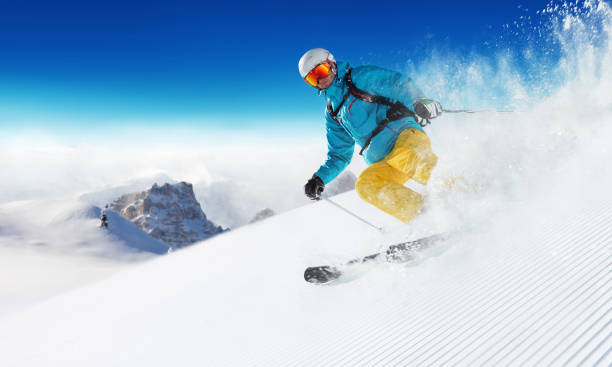 alpiner skifahrer auf der piste lauf - abfahrtslauf stock-fotos und bilder