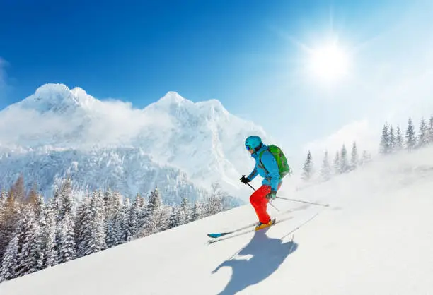 Photo of Free-ride skier in fresh powder snow running downhill