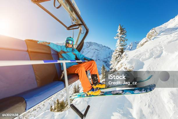 Skier Sitting At Ski Chair Lift In Alpine Mountains Stock Photo - Download Image Now