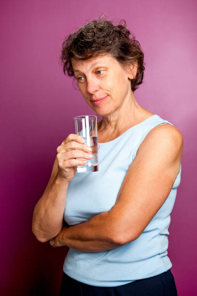 istock Pensive senior woman drinking water 643024504