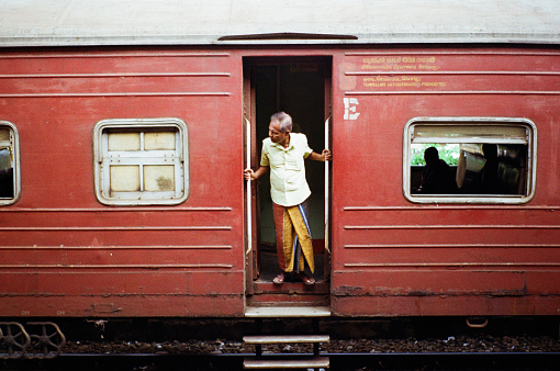 Old Sri Lankan man looking out of the train