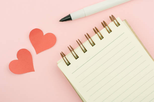 istock Pen laying and yellow notebook blank on pink background. 643032508